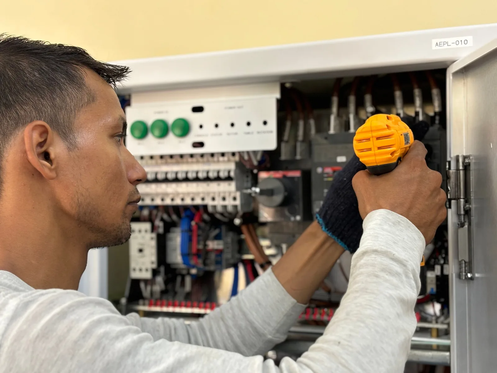 An electrician working on a commercial control panel, for panel upgrade in Barrie