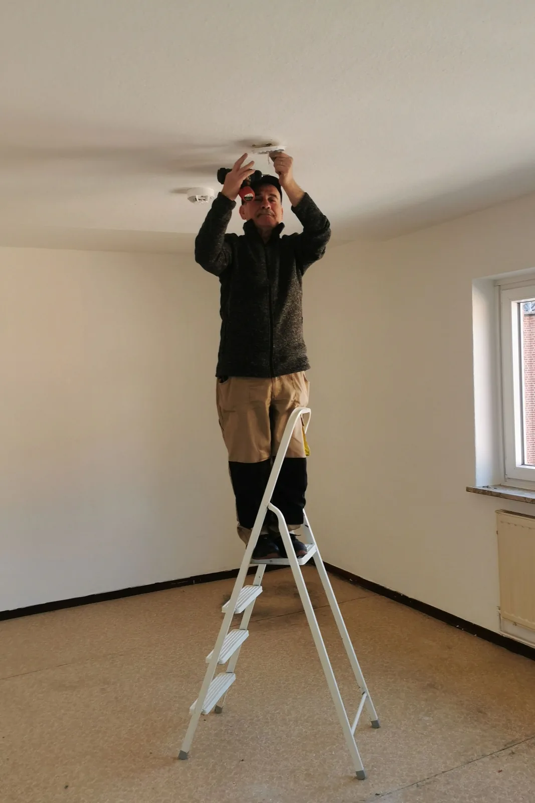 Fitting a ceiling detector from a step ladder, for ceiling fan installation in Barrie