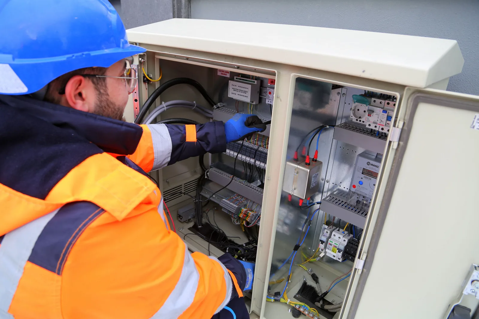 An electrician working in an outdoor service cabinet, for outdoor lighting in Barrie